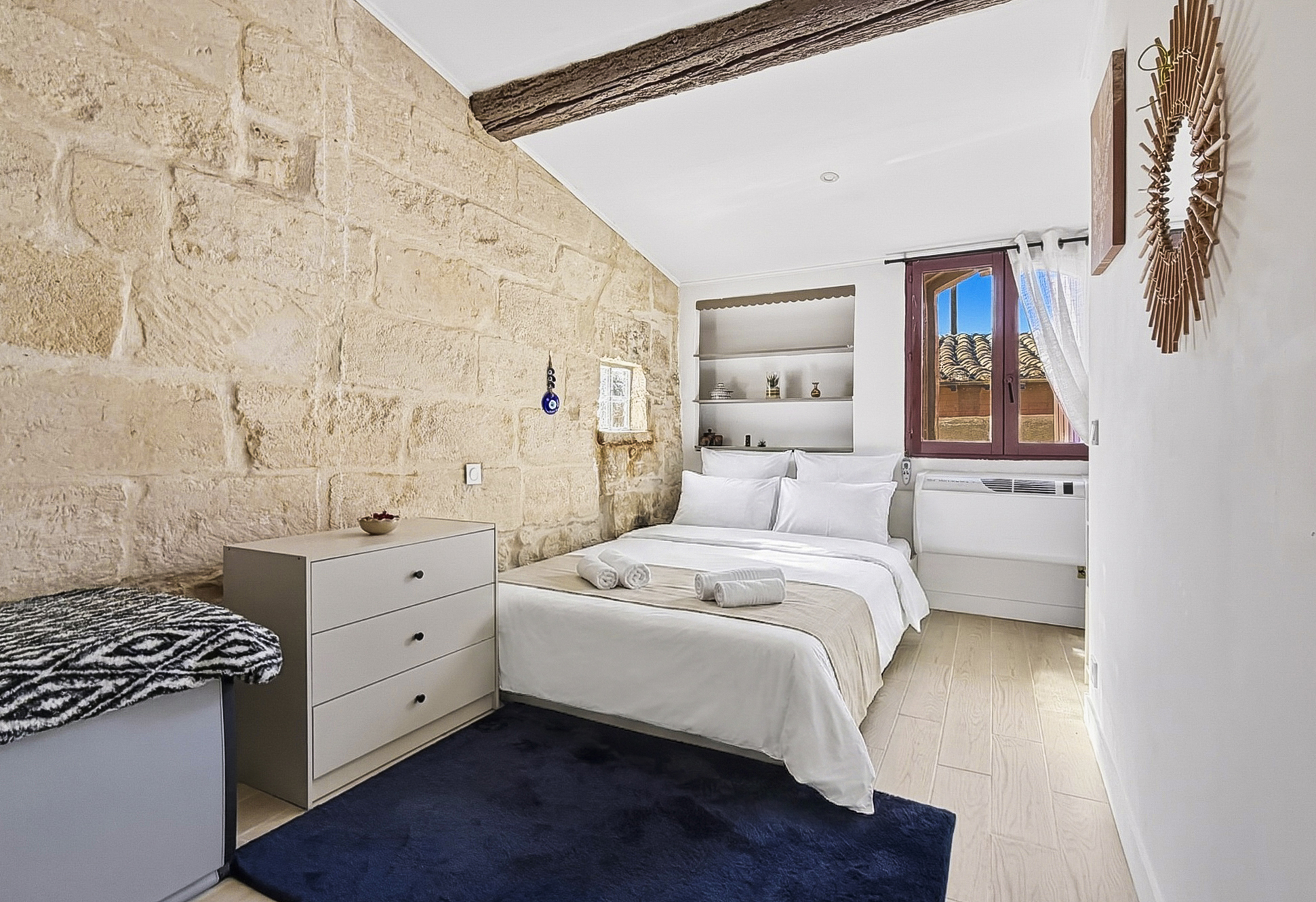 Chambre avec lit Queen size et pierres apparentes