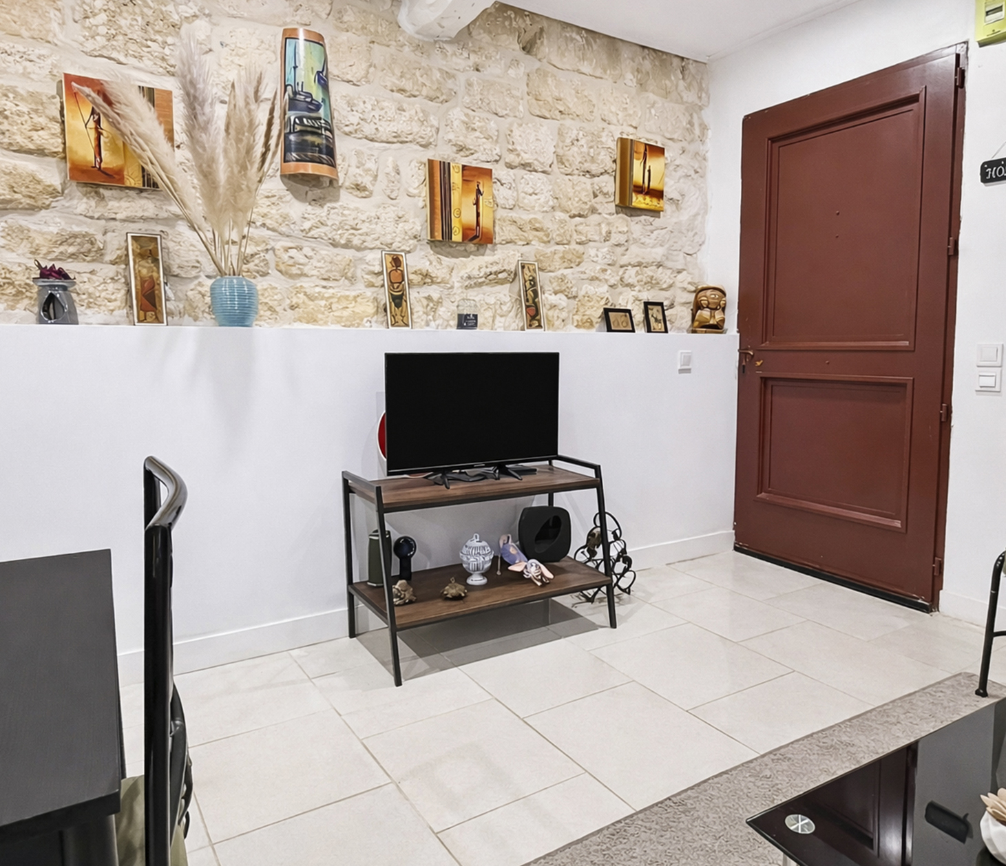 Mur en pierres apparentes avec meuble TV et objets de décoration